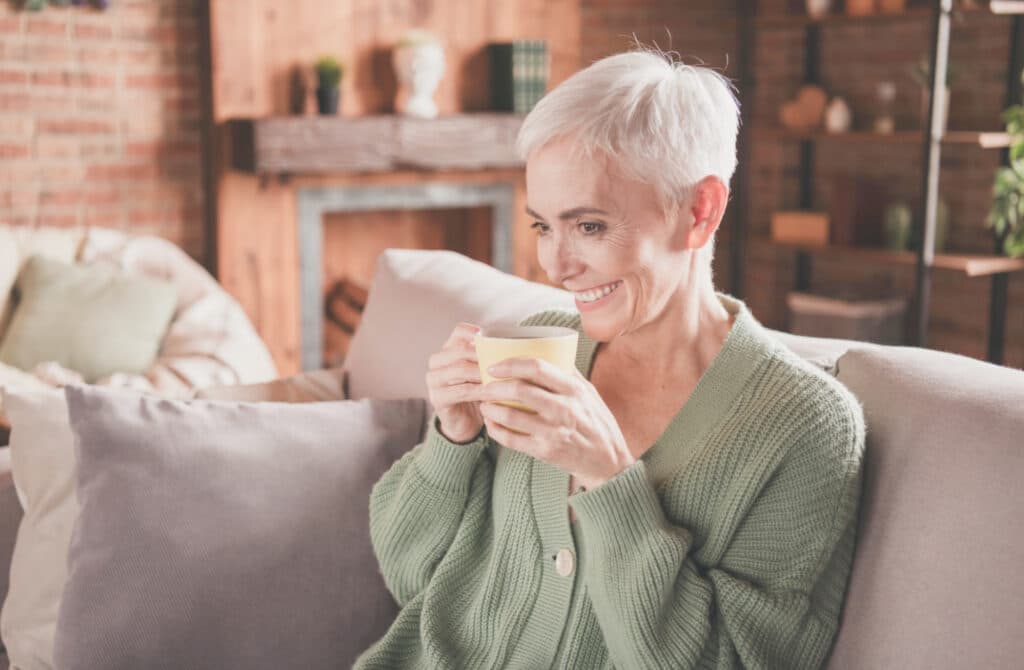 a midlife woman drinking coffee in a family room