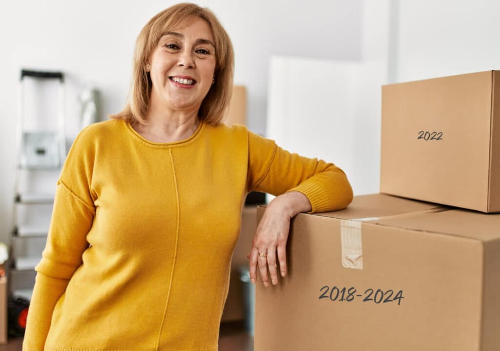 a woman smiling standing next to dated boxes