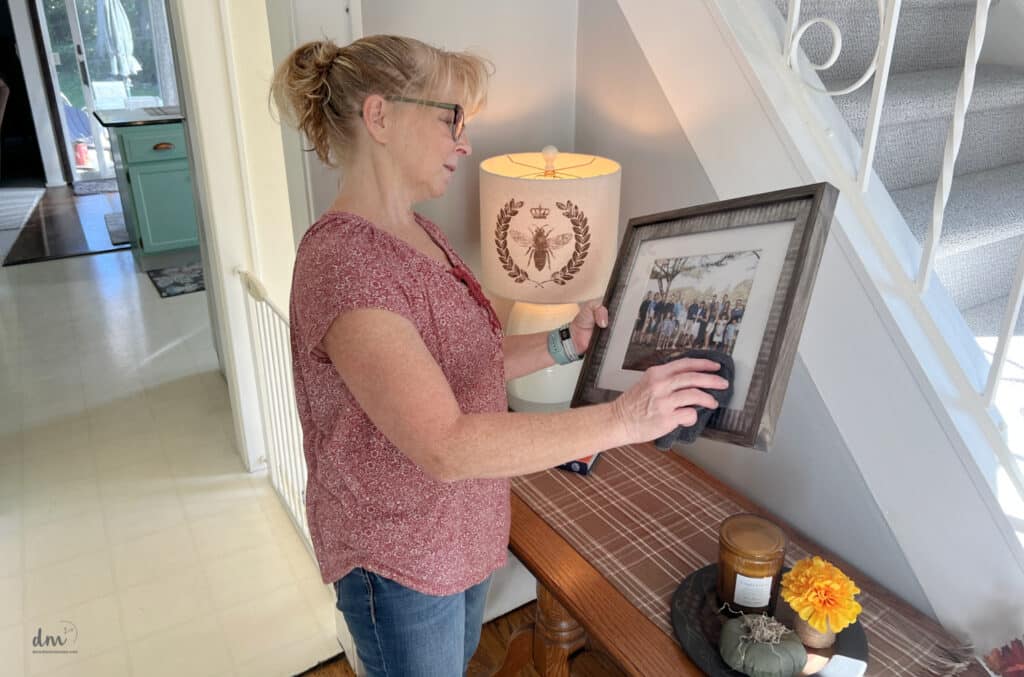 a woman dusting a family photo