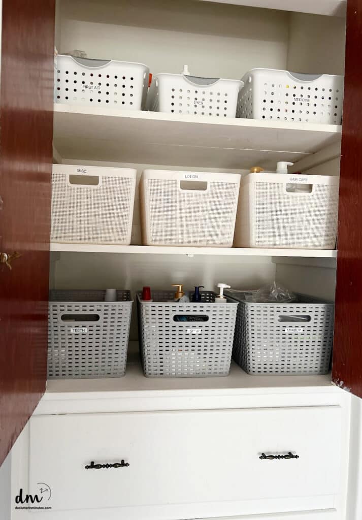 baskets in a linen closet that are neat and labeled