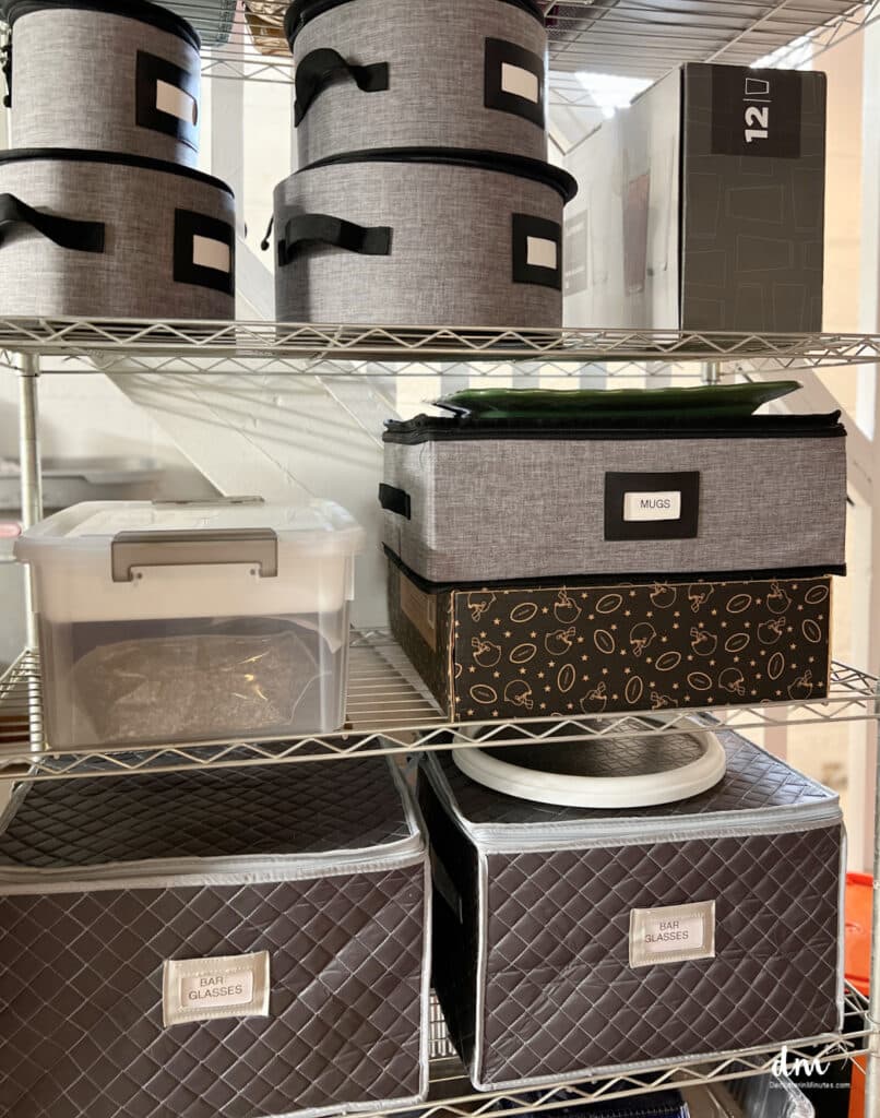 storage containers on a metal shelf holding dishes and glass ware